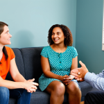Modern Family Counseling Session**

"A bright and welcoming family counseling office. A fully clothed, professional female counselor sits across from a diverse family (mother, father, child) in modest attire. They are engaged in a positive and empathetic conversation. The environment includes comfortable seating, soft lighting, and calming artwork. Perfect anatomy, correct proportions, natural pose, well-formed hands, proper finger count, natural body proportions. Safe for work, appropriate content, fully clothed, family-friendly, professional setting."

**